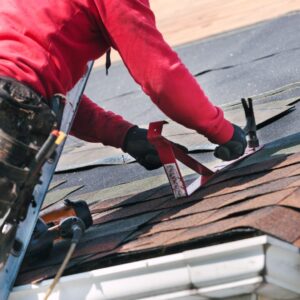 Roofing technician installing asphalt shingles with a roof gauge tool during a residential roof replacement. Ryan Construction Systems serves Kansas City, Parkville, Liberty, Riverside, and Gladstone with expert roof installation and repair. Trust a top-rated roofing company near you for precision, safety, and long-lasting results.