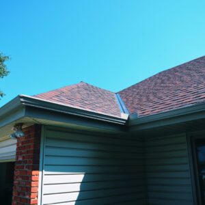 Newly shingled residential roof in Kansas City against a bright blue sky, showing quality roofing work.