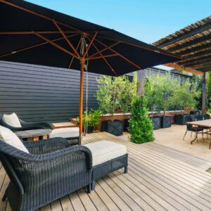 Outdoor living space patio and deck with an umbrella and lawn chairs