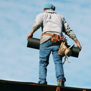 Man stands on roof to help with a repair or roof installation