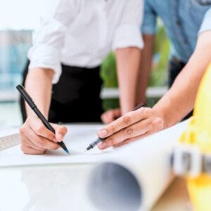 Construction professionals planning a Kansas City home remodeling project with detailed architectural drawings.