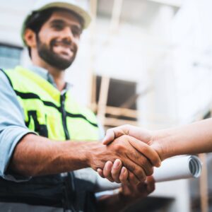 Trusted Kansas City contractor shaking hands with homeowner after completing a roofing or remodeling project.