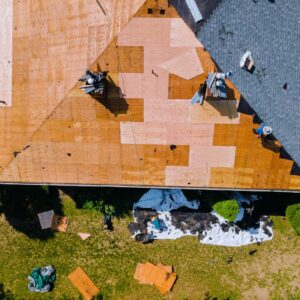 Aerial view of Kansas City roof under repair showing plywood decking and shingle removal during a residential roof replacement by local contractors.